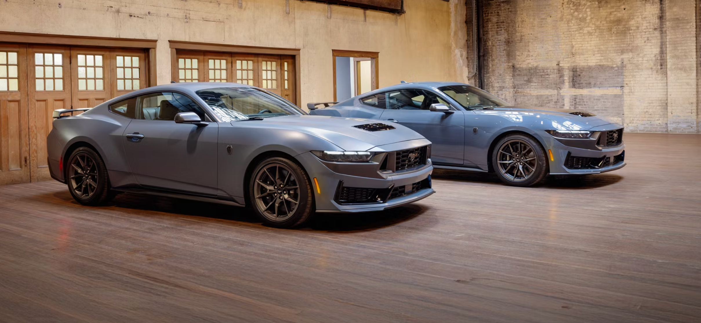 Two new gray 2026 Ford Mustangs in showroom near Orange, TX